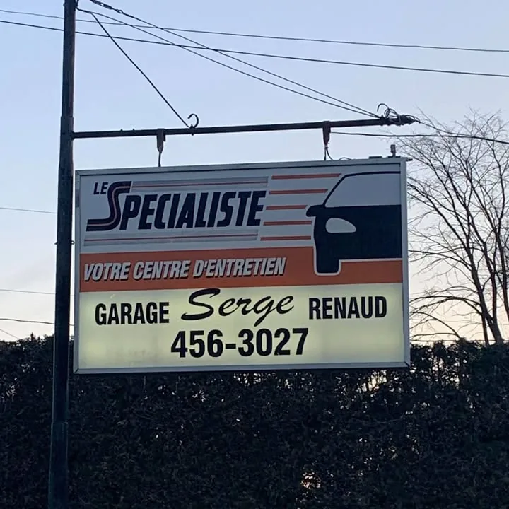 L'enseigne sur poteau du garage : « Garage Serge Renaud », 456-3027, sous la bannière Le Spécialiste — votre centre d'entretien